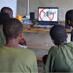Schoolboys watch a DVD lesson teaching them how to avoid Malaria